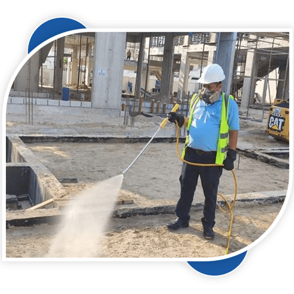 man holding the spray gun for anti termite control at construction building