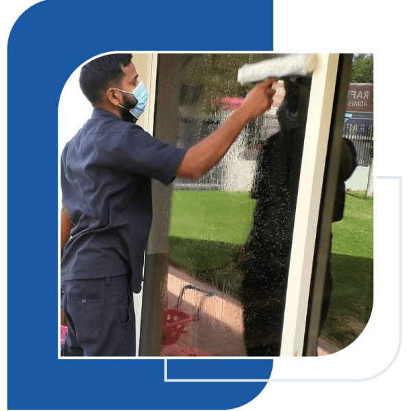 a man wiping the glass window-cleaning services dubai