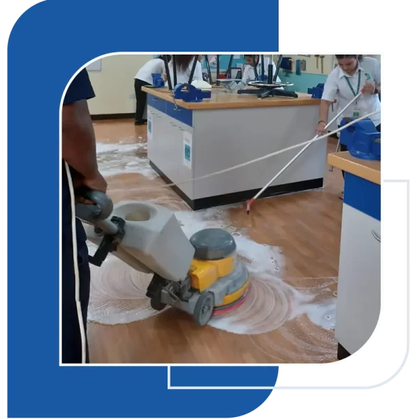 A group of people cleaning a floor with machine.