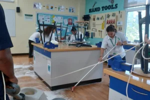 Group of people cleaning the floor with mop and machine