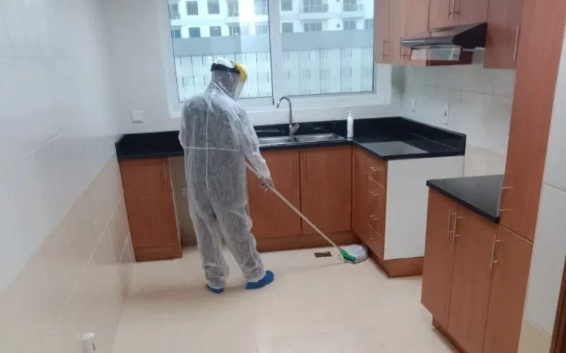 cleaner cleaning the floor by wearing the PPE kit