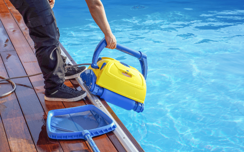 cleaners clining the pool with succing machine