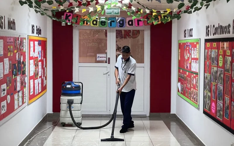 cleaner cleaning the floor with vaccum machine