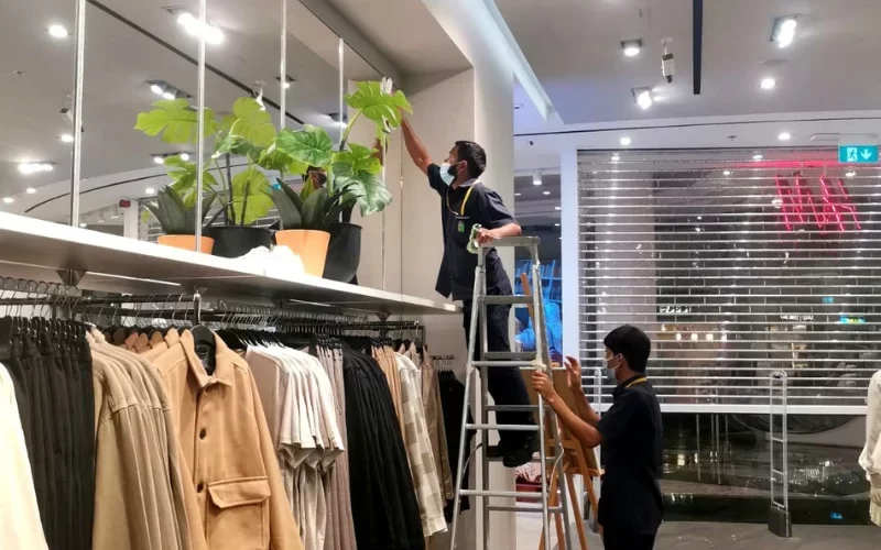 cleaners are cleaning the glass with the help of cradle